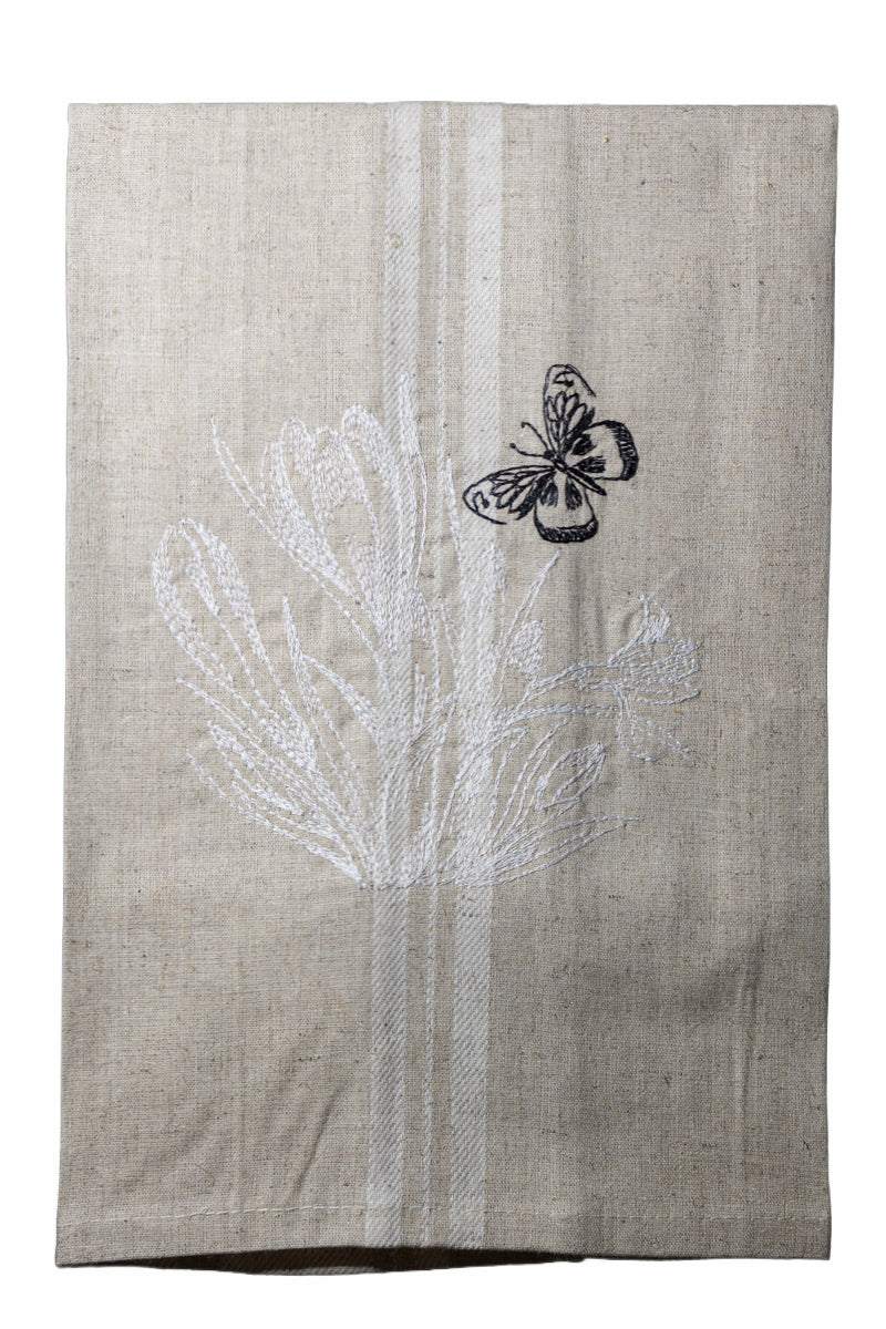 Dettaglio del ricamo Asciugapiatti ricamato con crocus e farfalla della collezione Vintage Stripes Noir Botanique su fondo neutro.