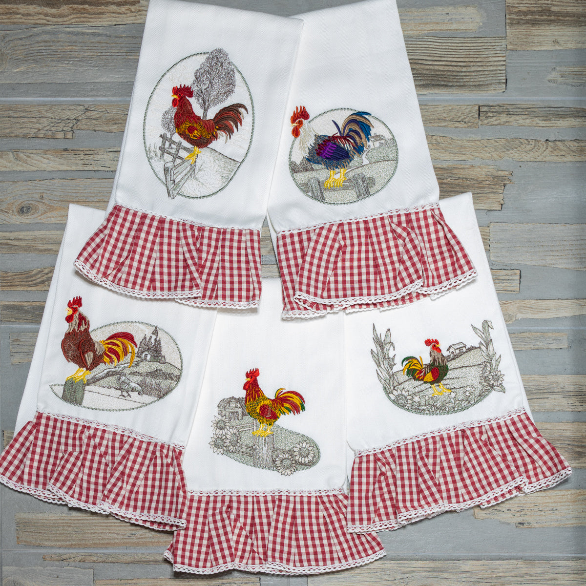 Asciugapiatti ricamati della collezione Mattine di Campagna con motivi rurali al mattino, esposti insieme.