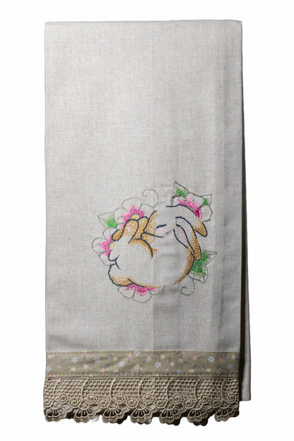 Asciugamano in cotone ricamato con coniglietto sognatore circondato da fiori rosa e verdi su sfondo bianco.