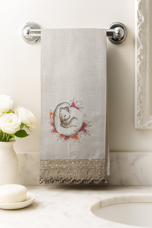 Asciugamano in cotone con ricamo scoiattolo dei sogni avvolto in foglie autunnali, fotografato appeso in un bagno elegante.