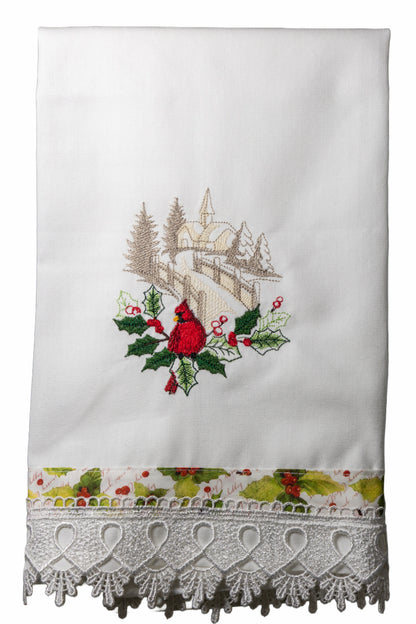 Asciugamano in cotone bianco con ricamo cardinale rosso e paesaggio innevato, bordo fantasia con agrifogli e pizzo bianco a frange.