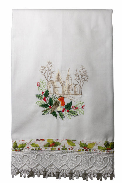 Asciugamano in cotone bianco con ricamo pettirosso tra agrifogli e villaggio innevato, bordo stampato natalizio e pizzo bianco.