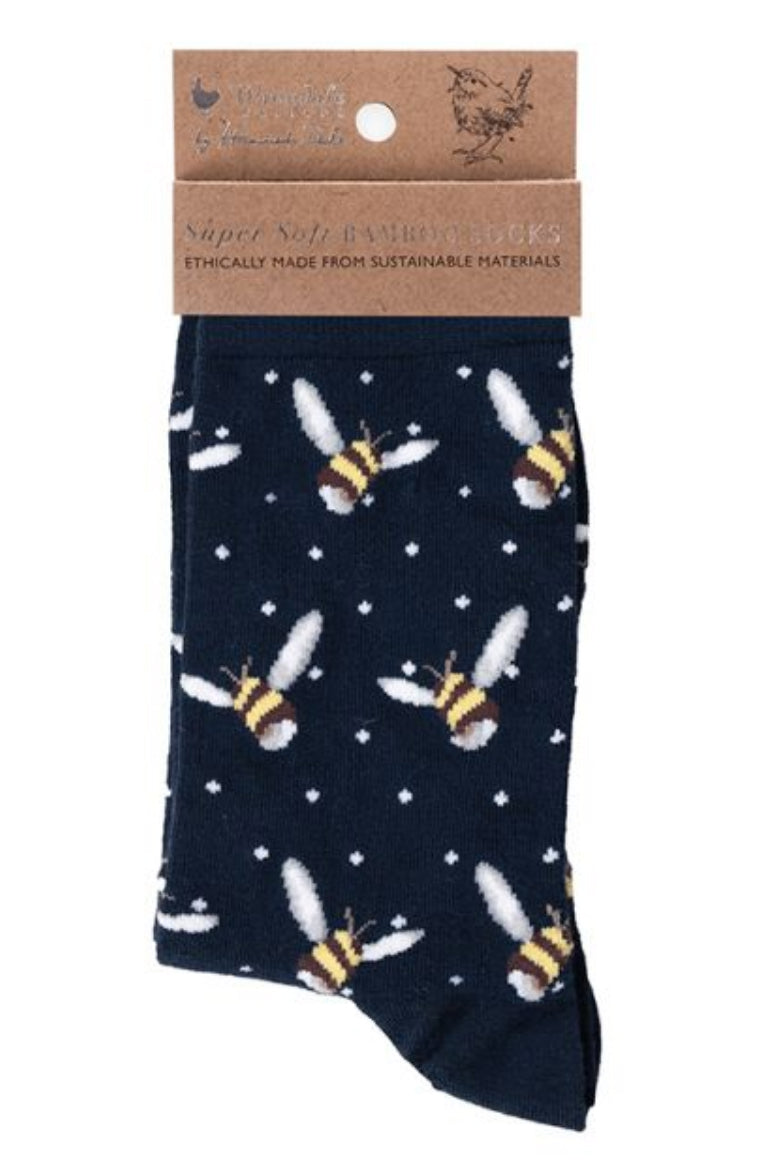 Calza da donna Wrendale Designs in bambù blu navy con motivo all-over di api ricamate, presentata con cartoncino kraft del brand su sfondo neutro.