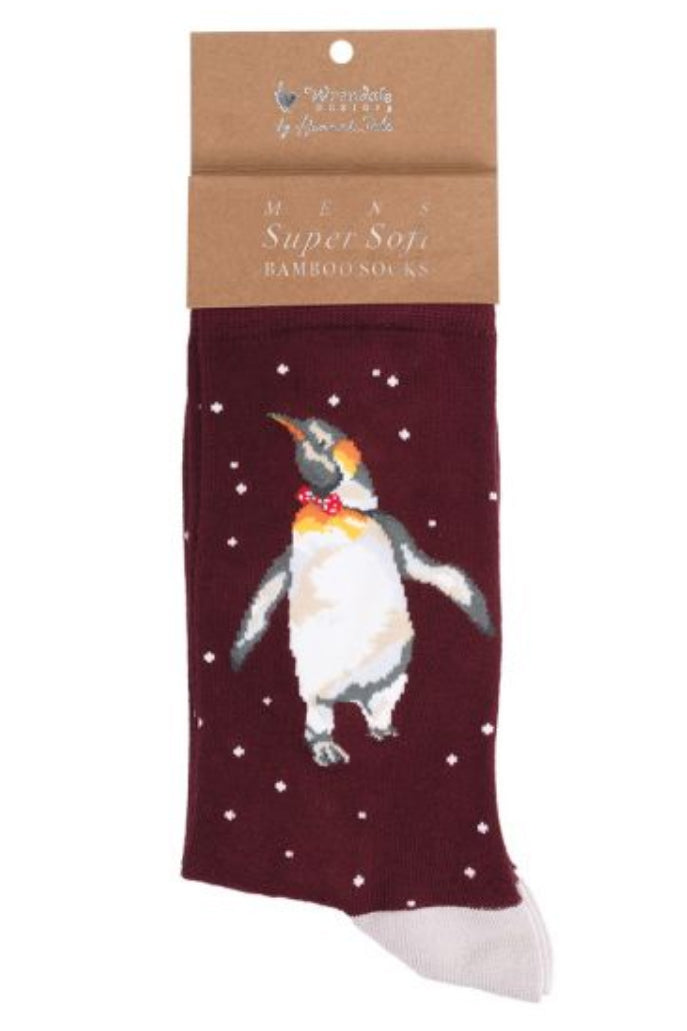 Calza da uomo Wrendale Designs in bambù bordeaux con ricamo di un pinguino reale con papillon rosso, presentata su sfondo neutro con cartoncino kraft del brand.