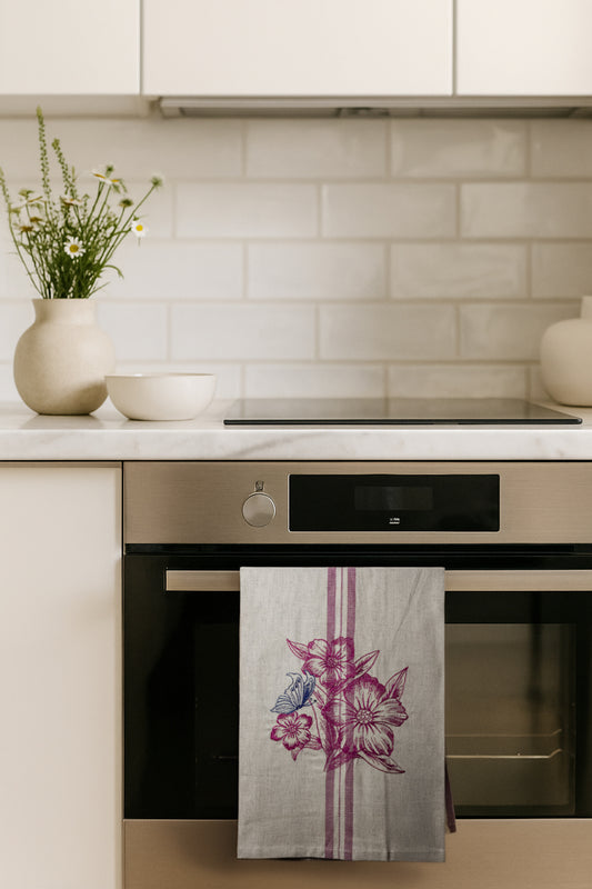 Asciugapiatti ricamato con anemoni e farfalla della collezione Vintage Stripes Fleurs Colorées, fotografato in cucina moderna.