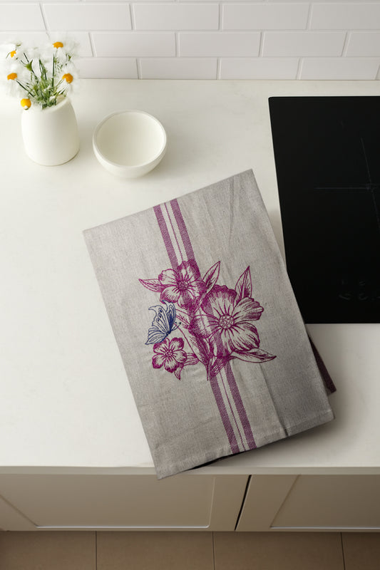 Asciugapiatti ricamato con anemoni e farfalla della collezione Vintage Stripes Fleurs Colorées, fotografato dall'alto in cucina moderna.