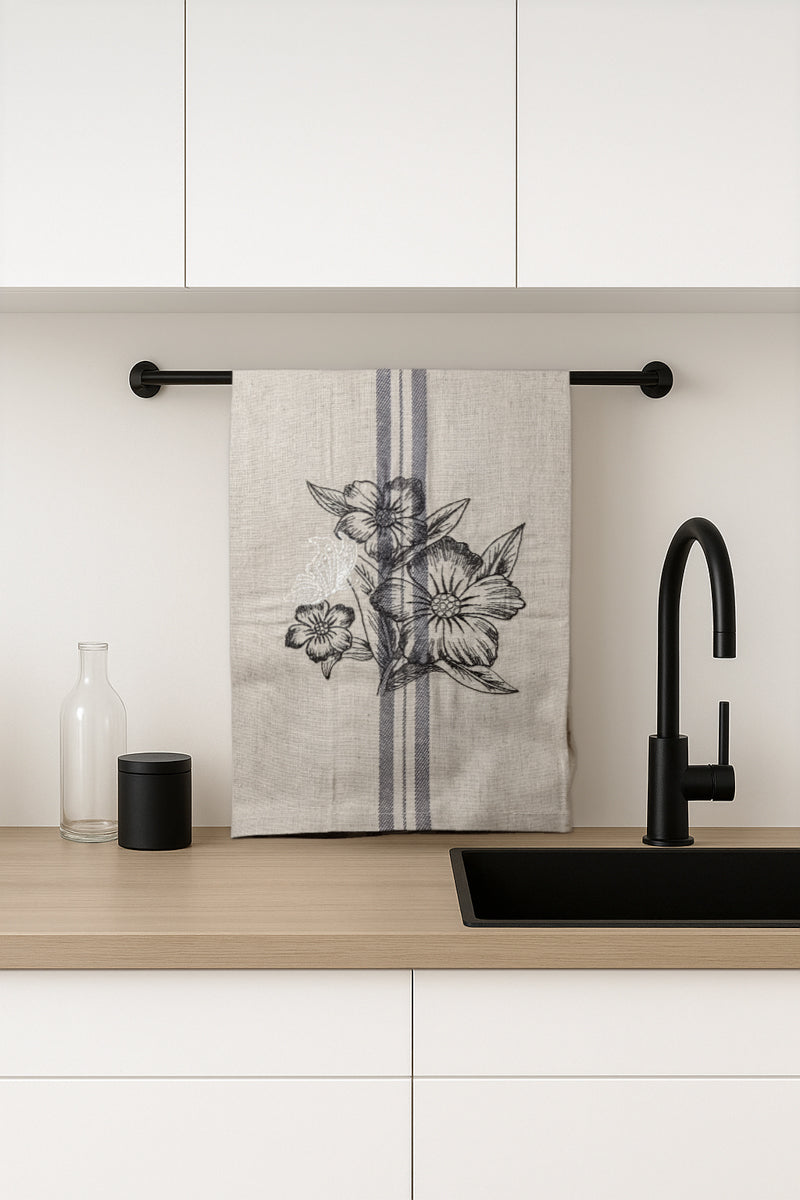 Asciugapiatti ricamato con anemoni e farfalla della collezione Vintage Stripes Noir Botanique, fotografato in cucina moderna.