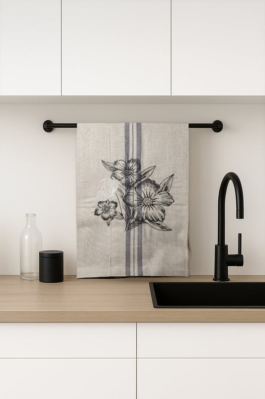 Asciugapiatti ricamato con anemoni e farfalla della collezione Vintage Stripes Noir Botanique, fotografato in cucina moderna.