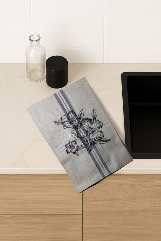 Asciugapiatti ricamato con anemoni e farfalla della collezione Vintage Stripes Noir Botanique, fotografato dall'alto in cucina moderna.