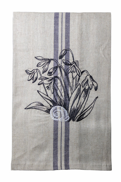 Dettaglio del ricamo Asciugapiatti ricamato con bucaneve e chiocciola della collezione Vintage Stripes Noir Botanique su fondo neutro.