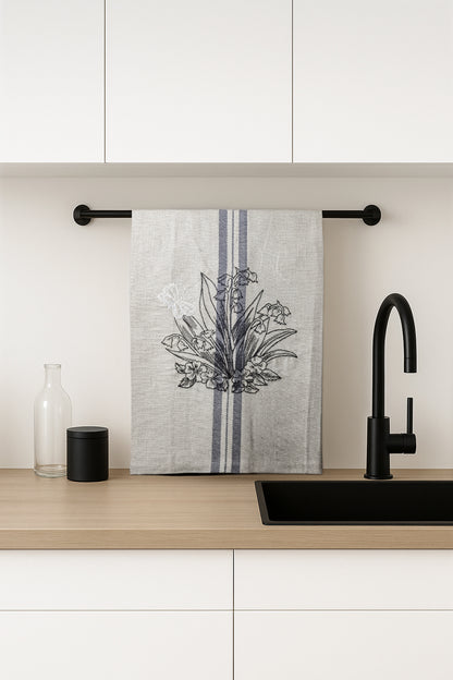 Asciugapiatti ricamato con mughetti e farfalla della collezione Vintage Stripes Noir Botanique, fotografato in cucina moderna.