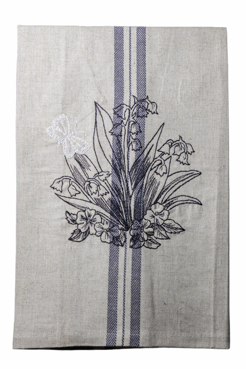 Dettaglio del ricamo Asciugapiatti con mughetti e farfalla della collezione Vintage Stripes Noir Botanique su fondo neutro.