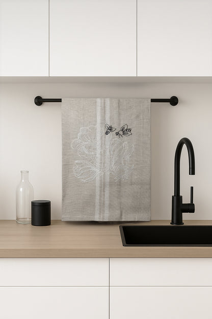 Asciugapiatti ricamato con ranuncoli e api della collezione Vintage Stripes Noir Botanique, fotografato in cucina moderna.