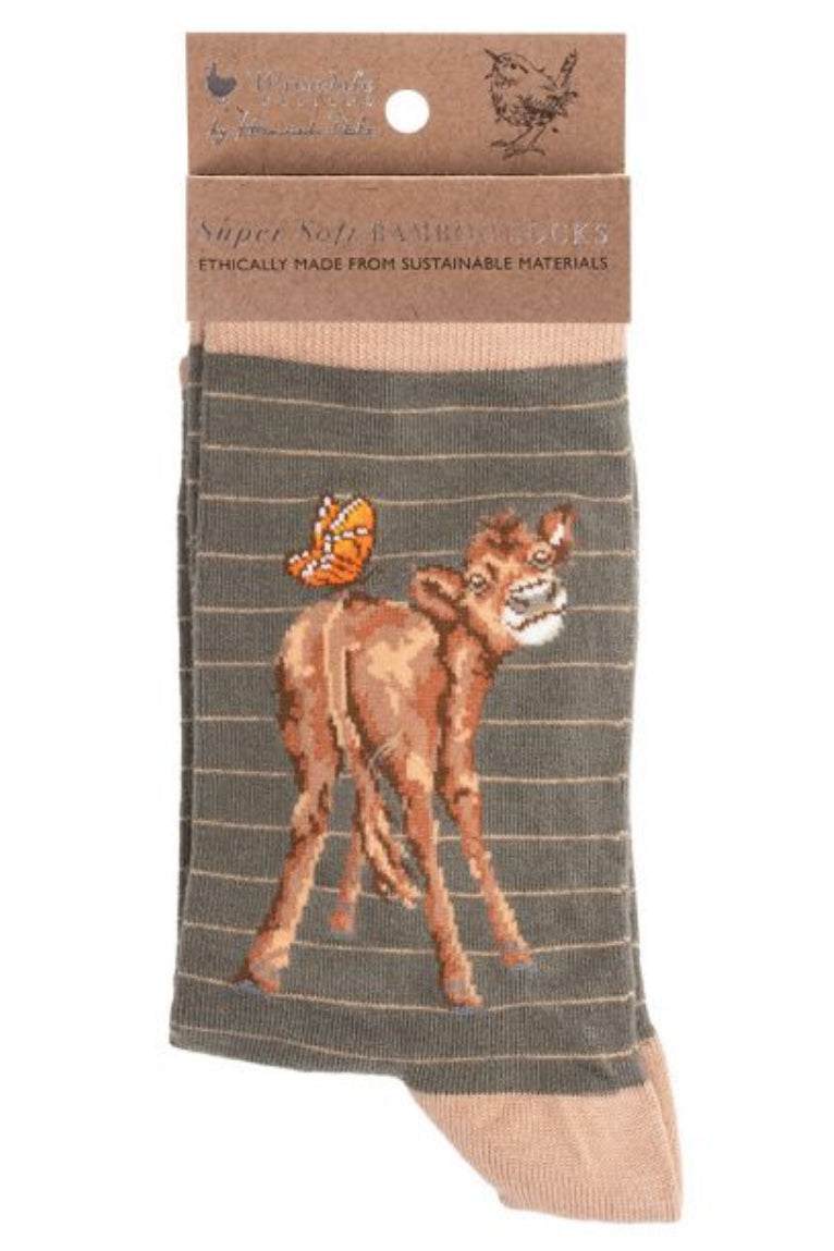 Calza da donna Wrendale Designs in bambù color tortora a righe sottili con ricamo di vitellino e farfalla arancione, presentata con cartoncino kraft del brand su sfondo neutro.