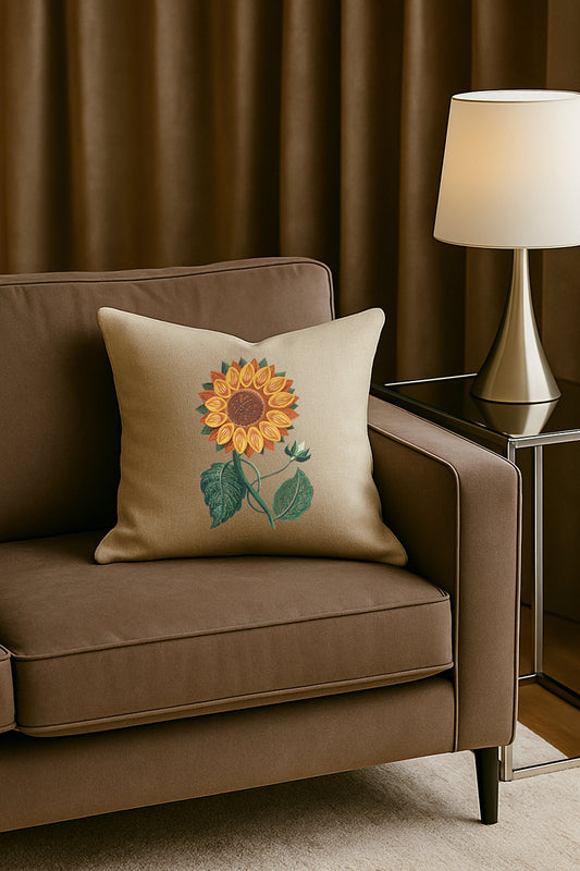 Cuscino in misto lino beige con ricamo 3D di girasole giallo, posato su un divano marrone in un soggiorno elegante con lampada dorata e tende scure.