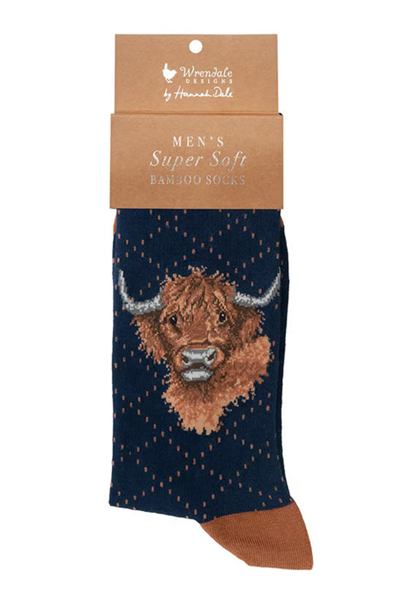 Calza da uomo Wrendale Designs in bambù blu notte profondo con mucca delle Highlands ricamata, presentata su sfondo neutro con cartoncino kraft del brand.
