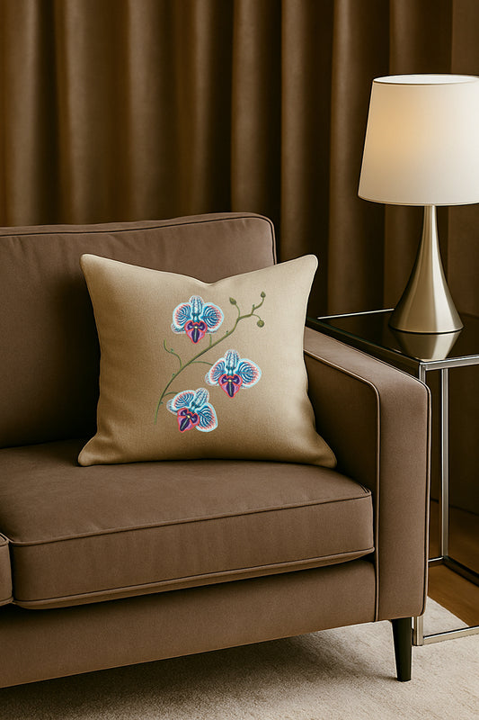 Cuscino decorativo in misto lino beige con ricamo tridimensionale di orchidea blu, posato su un divano marrone in un soggiorno elegante con lampada dorata e tende scure.