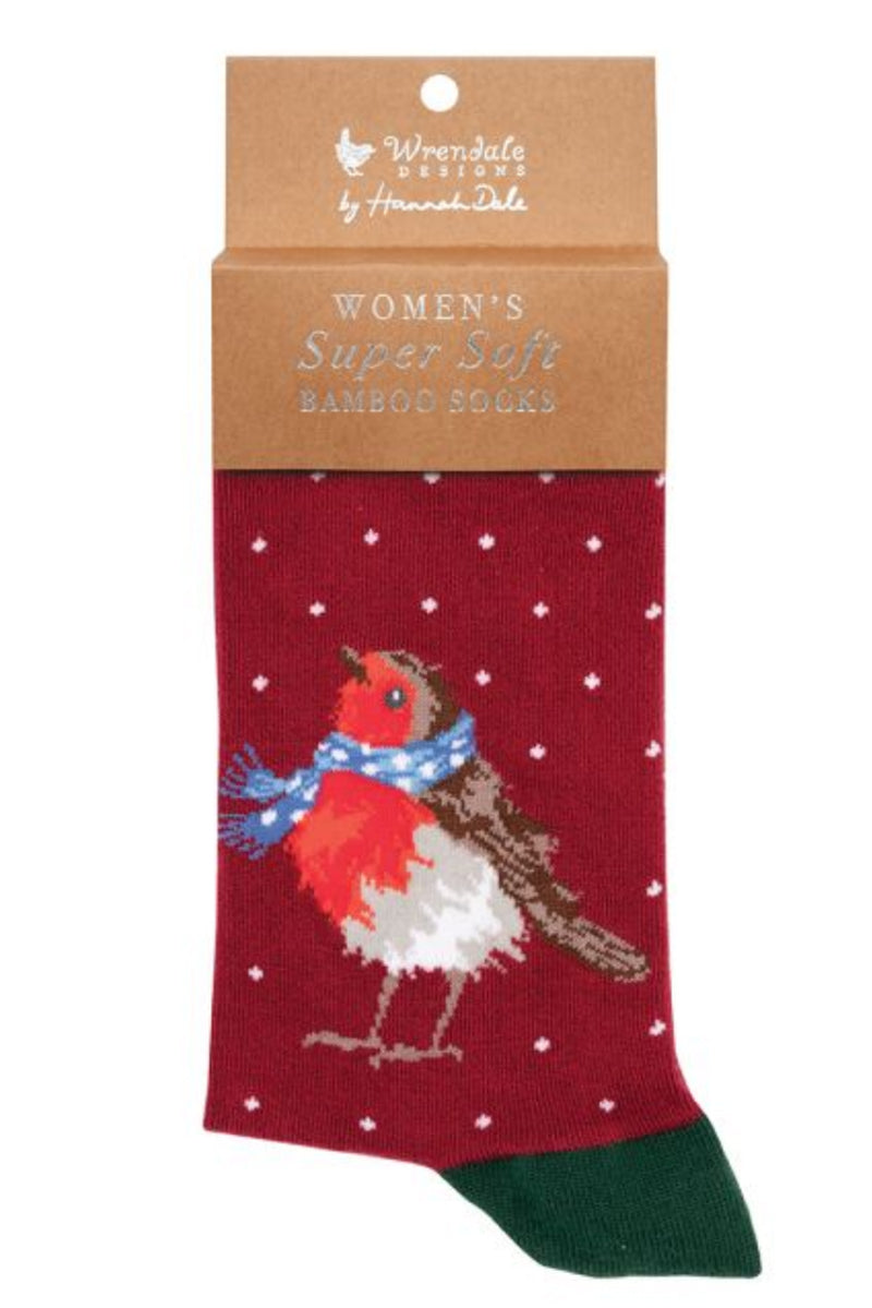 Calza da donna Wrendale Designs in bambù rosso con ricamo di Pettirosso con sciarpa invernale azzurra e piccoli pois bianchi, presentata con cartoncino kraft del brand su sfondo neutro.