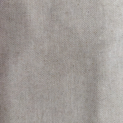 Dettaglio ravvicinato del tessuto in misto lino beige, con trama fitta e naturale utilizzata per i cuscini ricamati della collezione Fioriture in Rilievo.