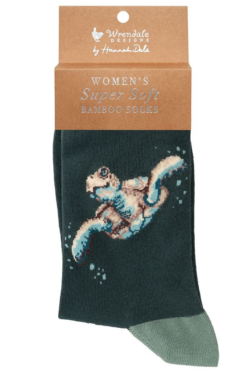 Calza da donna Wrendale Designs in bambù blu petrolio con tartaruga marina ricamata, presentata con cartoncino kraft del brand su sfondo neutro.
