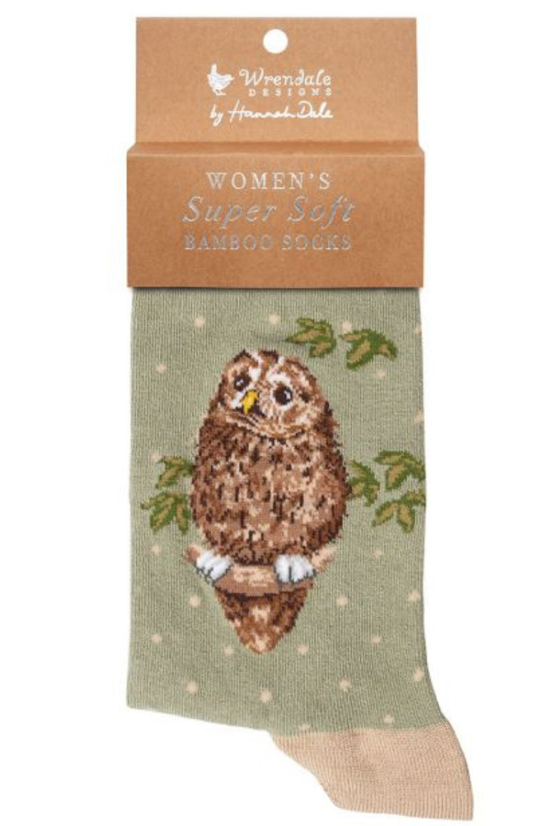 Calza da donna Wrendale Designs in bambù verde salvia con ricamo di gufetto posato su un ramo tra foglie, presentata con cartoncino kraft del brand su sfondo neutro.