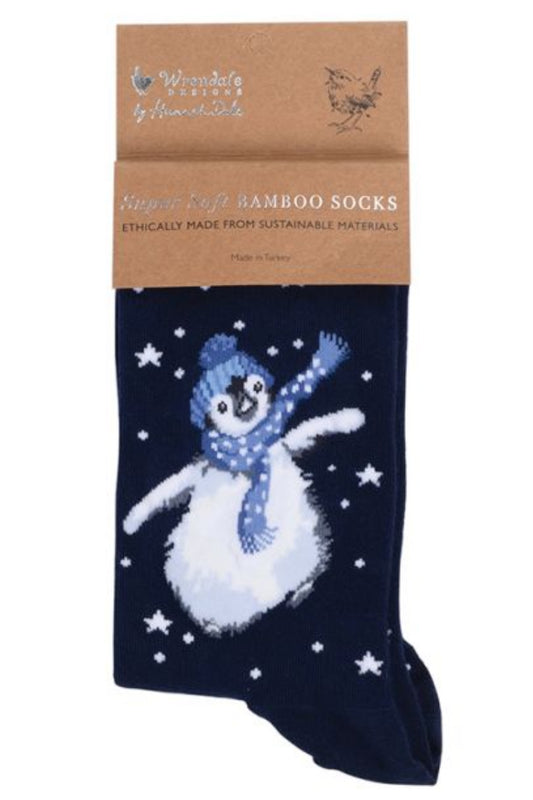 Calza da donna Wrendale Designs in bambù blu navy con ricamo di pinguino  nella neve, sciarpa e cappello blu a pois, presentata con cartoncino kraft del brand su sfondo neutro.